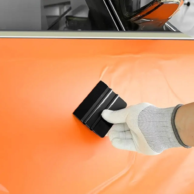 Folie wird mit Rakel auf Auto aufgetragen – blasenfreies Aufbringen von Car-Wraps oder Stickern