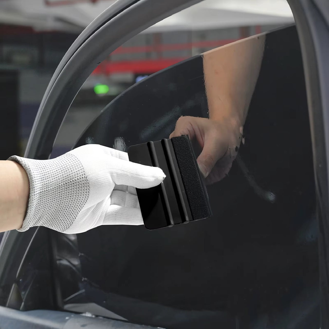 Sticker-Montage am Fahrzeug – Rakel mit Filz sorgt für kratzfreies Anbringen an der Karosserie